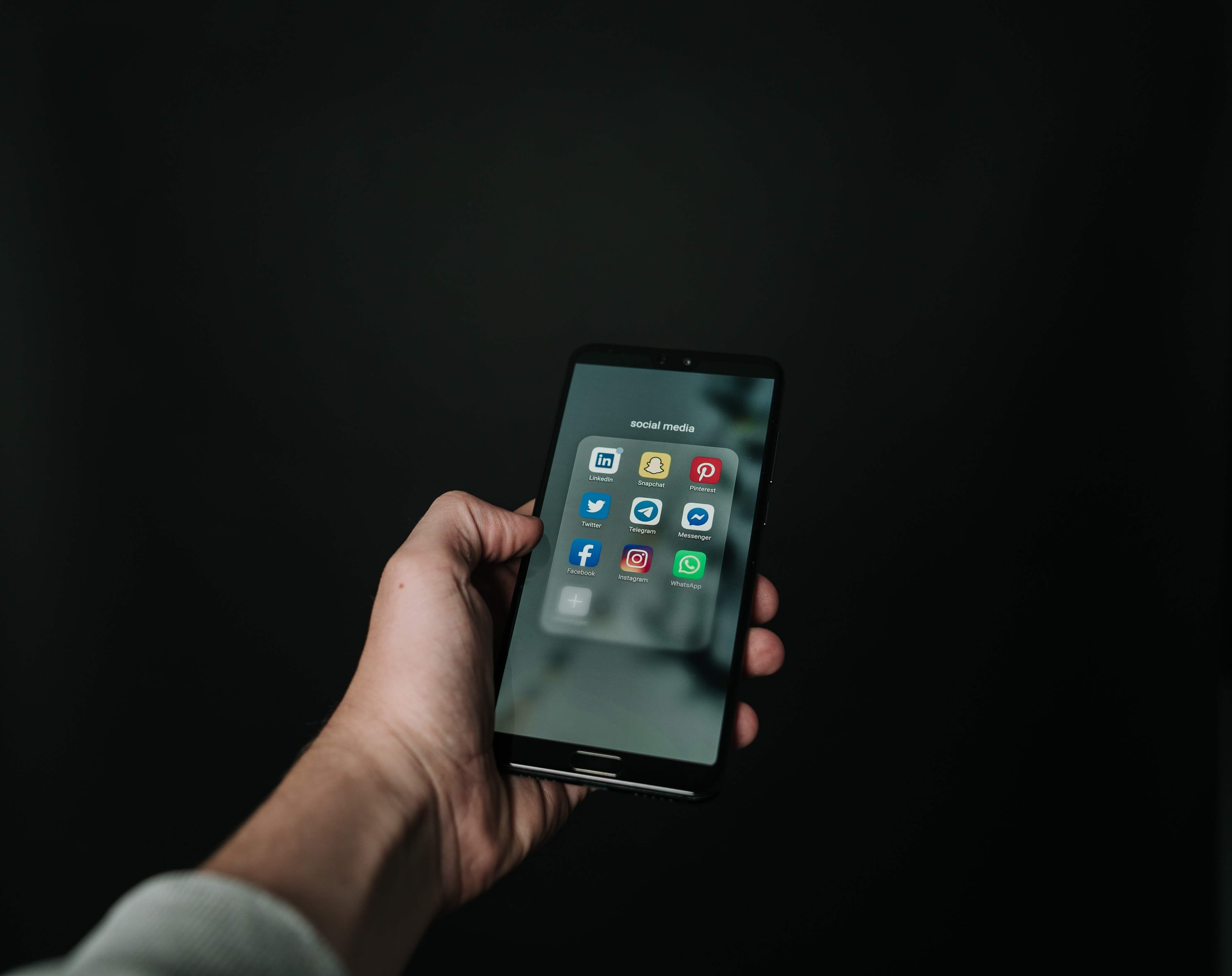 Phone screen showing the social media apps LinkedIn, Snapchat, Pinterest, Twitter, Telegram, Facebook, Instagram, and more.