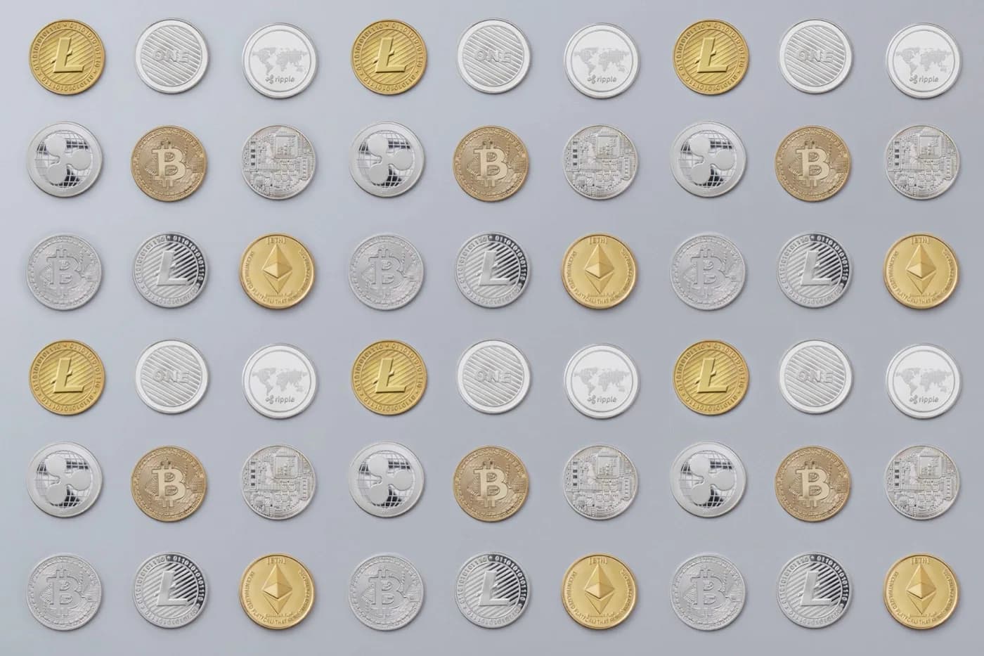 Fifty-four golden, bronze, and silver cryptocurrency coins all sitting out on a dark grey surface evenly separated and flat.