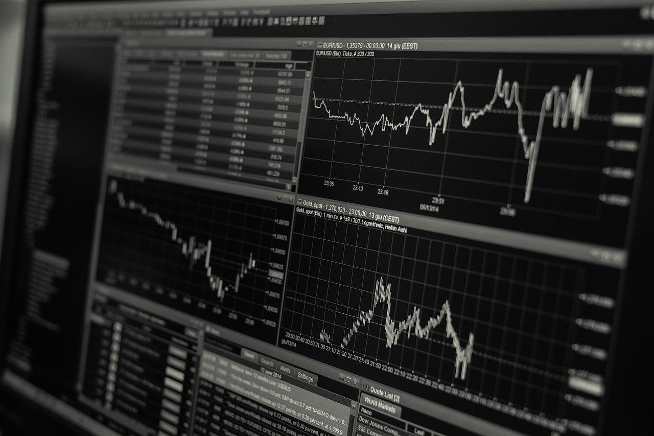 A black and white image of a computer screen that has three different line charts and multiple datasets for market analysis.