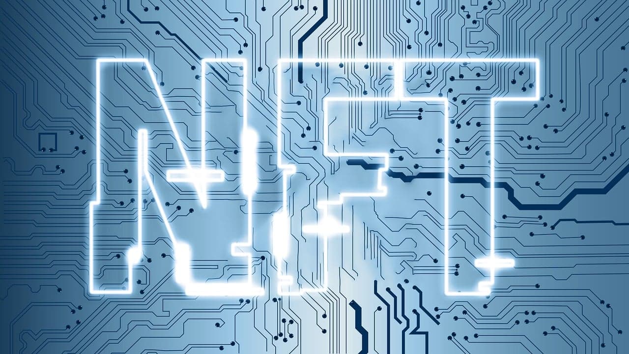 NFT is written in white outlined letters in front of a light blue circuit board patterned background with dark blue lines.