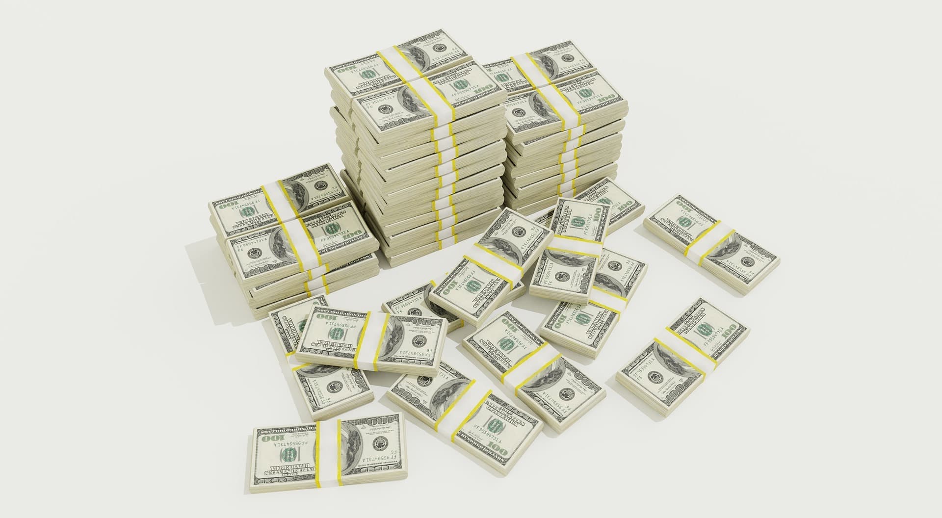 Multiple stacks of one hundred dollar bills placed on top of each other in six different stacks surrounded by more hundreds.