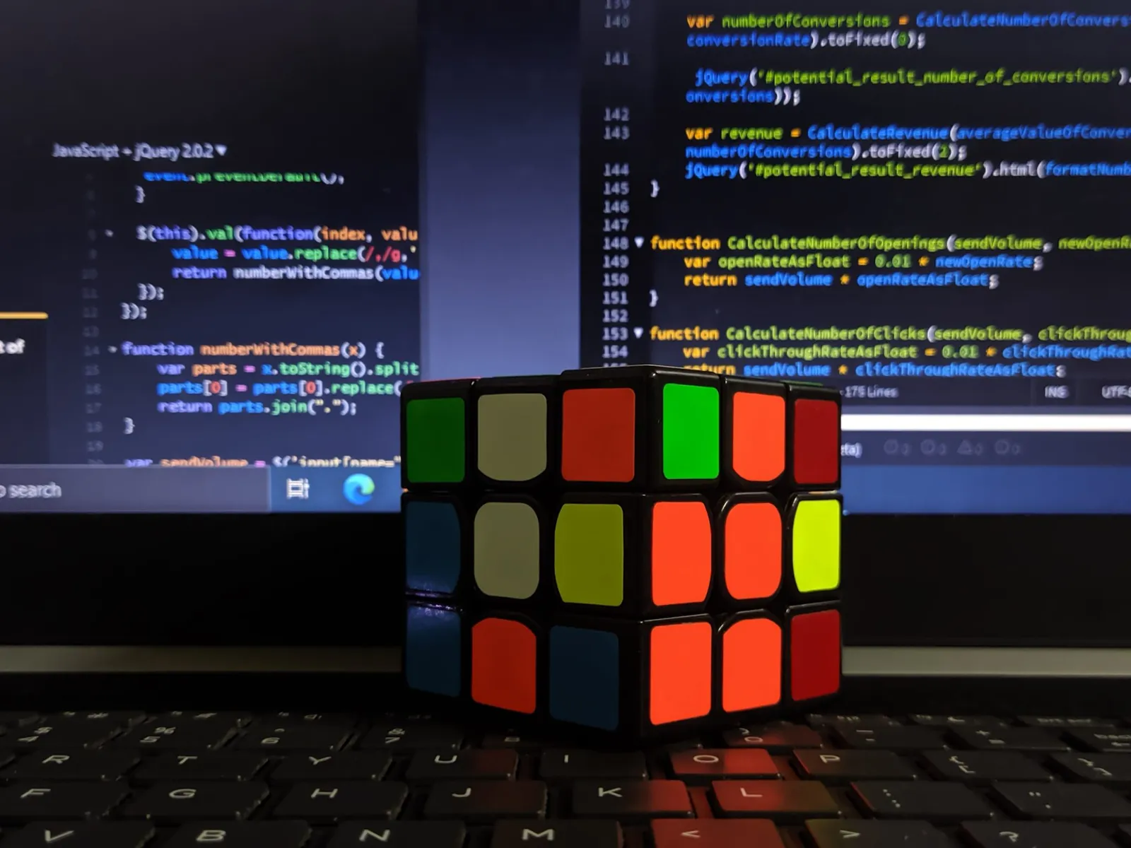 Puzzle cube in front of a screen of code, illustrating AI models passing coding skill through one-word answers
